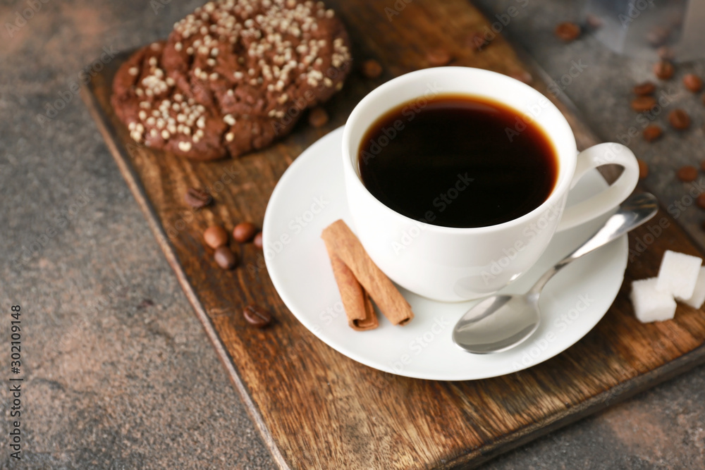 Cup of hot coffee and cookies on table