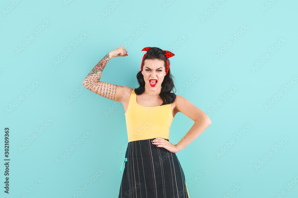 Portrait of strong tattooed pin-up woman on color background - obrazy, fototapety, plakaty 