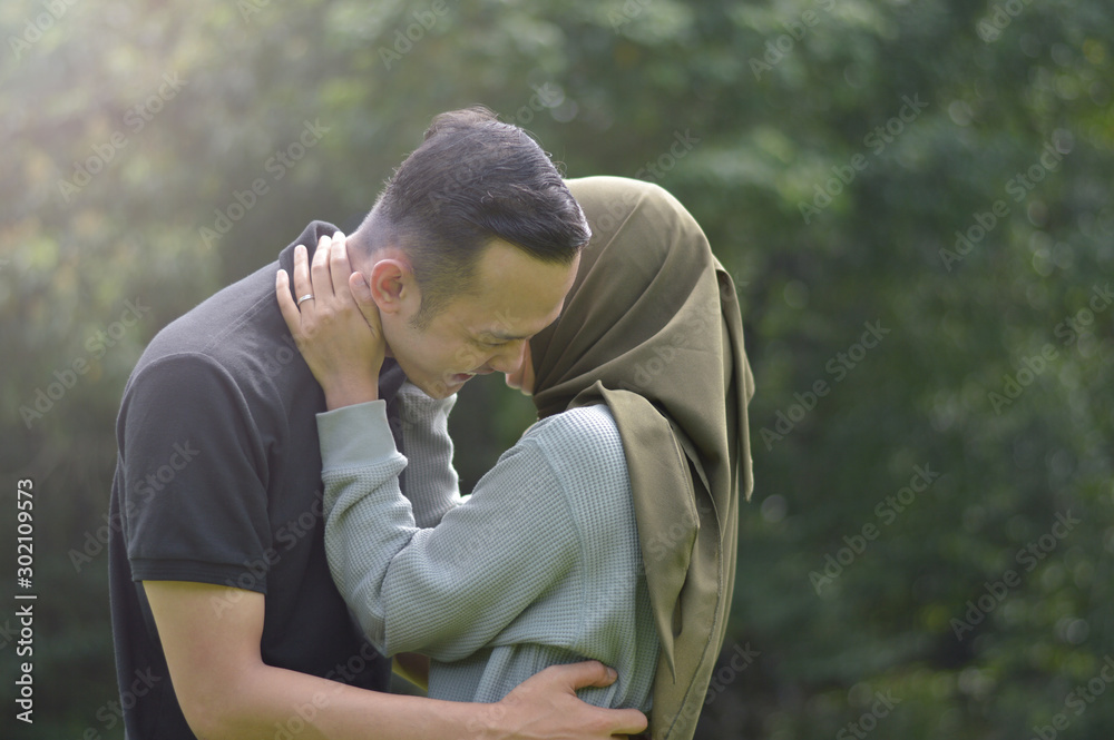 lovely asian Muslim young couple embracing at outdoors lovely asian Muslim young couple embracing at outdoors