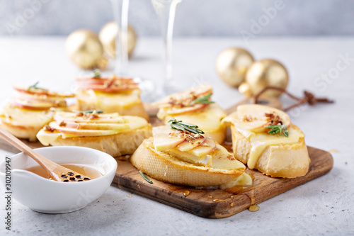 Pear and brie crostini with honey, pecan and rosemary, New Years Eve or Christmas party appetizer photo