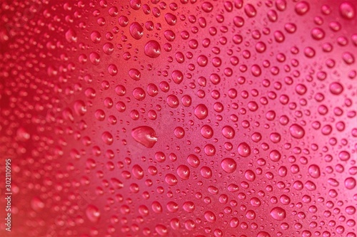 Raindrops on a glass background  red raspberries. Texture of a drop of water on glass.