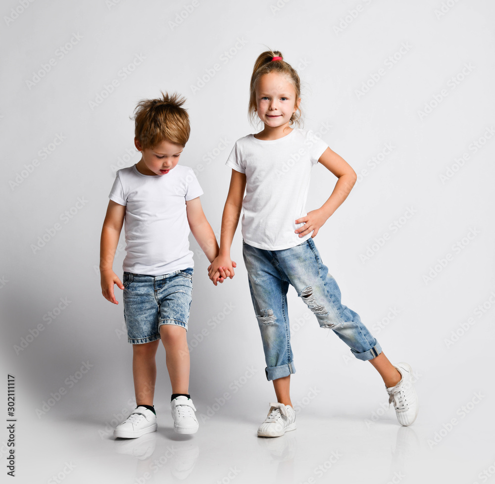 Kid girl and little boy in blue jeans and white t shirt are