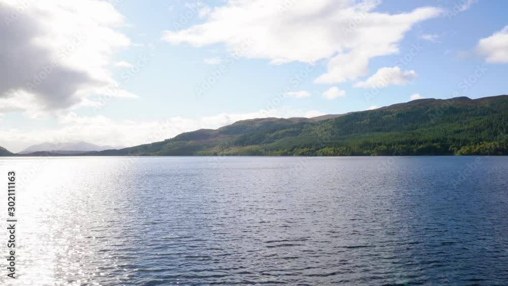 Pan of Loch Ness and Green Hills, Clear Blue Sky to Grey Overcast Sky