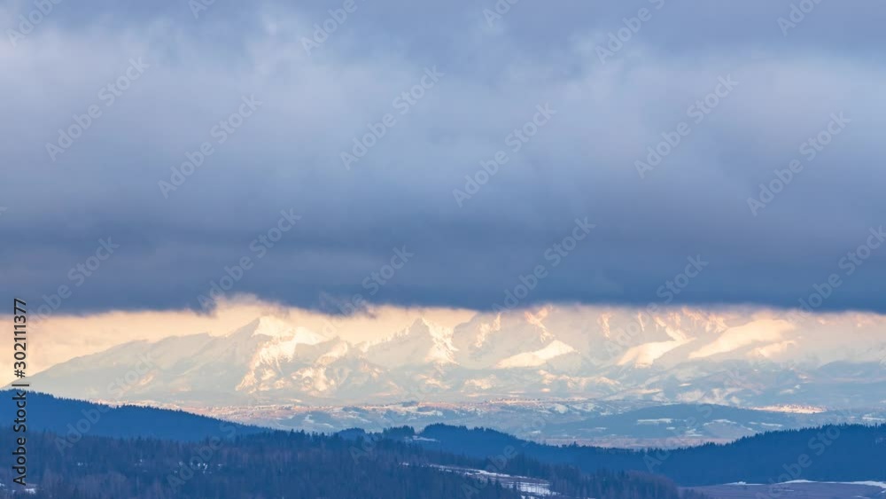 Clouds flying over Tatra mountains during sunset.  Video with camera motion.