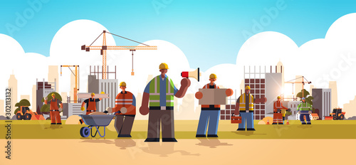 builders team wearing hard hat busy workmen standing together mix race industrial workers in uniform building concept construction site background flat full length horizontal vector illustration