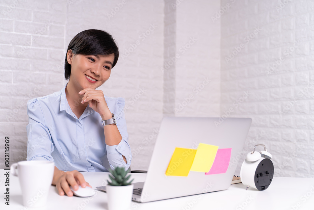 Happy woman sitting at home office working using computer laptop Happy woman sitting at home office working using computer laptop