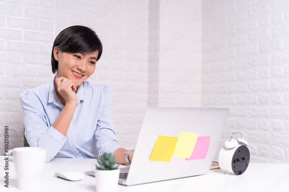 Happy woman sitting at home office working using computer laptop Happy woman sitting at home office working using computer laptop