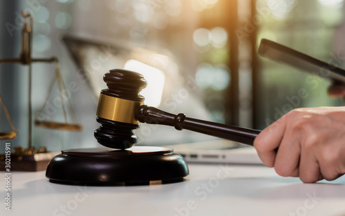 law legal technology concept. judge gavel on computer with scales of justice on desk of lawyer.