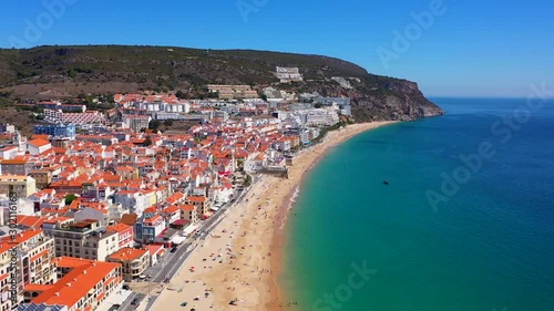 Aerial, static, drone shot, overlooking the coast of the Sesimbra city and the Praia da California beach, on a sunny day, in Lisbon, Portugal photo