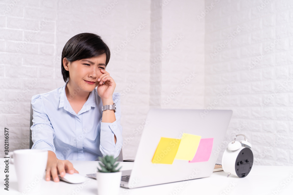 Sad woman sitting at home office working using computer laptop Sad woman sitting at home office working using computer laptop