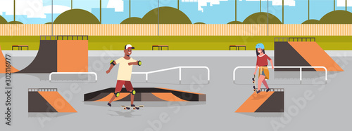 skaters performing tricks in public skate board park with various ramps for skateboarding mix race teenagers couple having fun riding skateboards landscape background flat full length horizontal