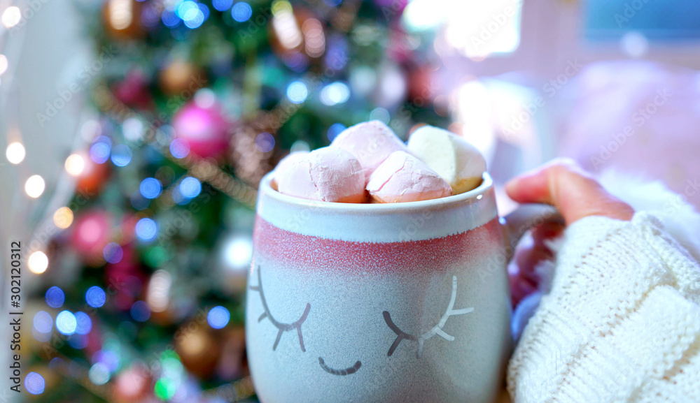 Φωτογραφία Woman holding hot chocolate in front of on trend pink and rose gold trimmed Christmas tree