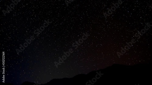 Night sky timelapse over a hill as seen from Bhujung Village, Lamjung, Nepal. Long Exposure, wide shot. photo