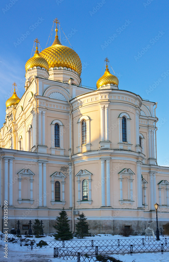 St. Petersburg in the Christmas holidays. Domes of the Cathedral of the Resurrection in the Novodevichy Convent in the rays of the setting sun and a church courtyard on a cold winter day
