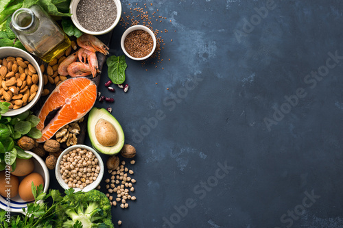 Food sources of omega 3 and healthy fats on dark background top view. Copy Space. Vegetables, seafood, nut and seed photo