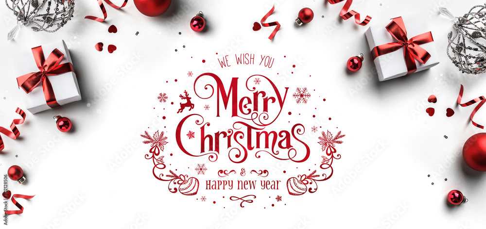 Merry Christmas and New Year text on white background with gift boxes, ribbons, red decoration, bokeh, sparkles and confetti. Xmas greeting card, bokeh, light. Flat lay, top view - obrazy, fototapety, plakaty 