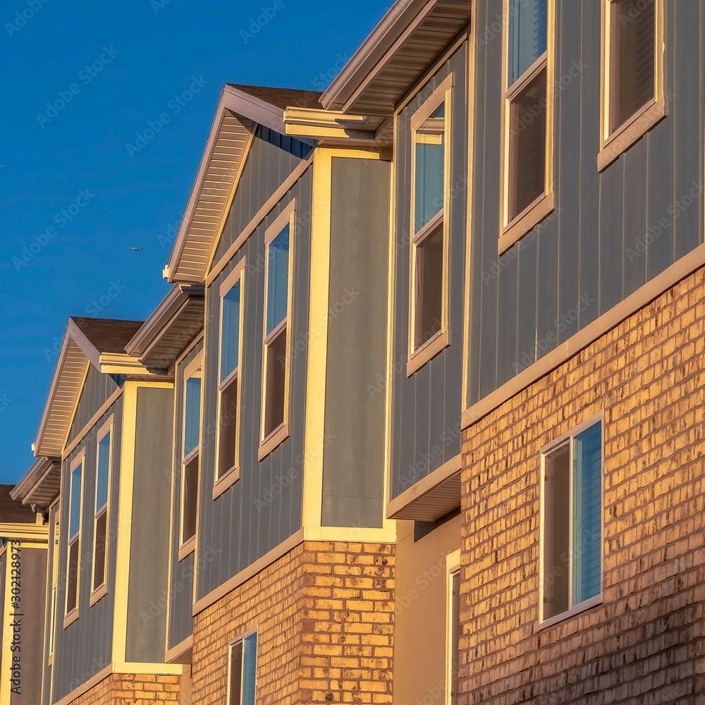 Square Townhomes on a neighborhood with vibrant blue sky background on a sunny day