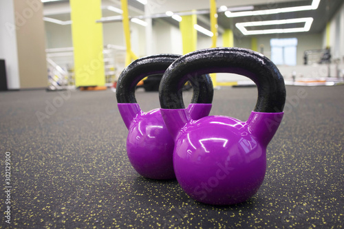 Fototapeta Naklejka Na Ścianę i Meble -  two kettlebells on the floor in the gym, the concept of sports and exercise