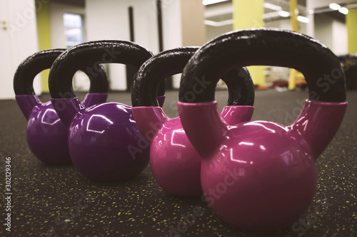 Fototapeta Naklejka Na Ścianę i Meble -  multi-colored kettlebells in the gym, the concept of sports and physical activity