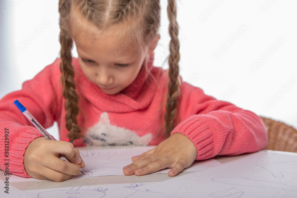 the girl draws a pencil around her hand on the paper the girl draws a pencil around her hand on the paper