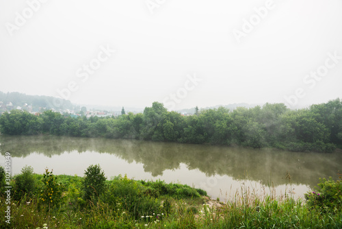 Calm river with forest in misty morning