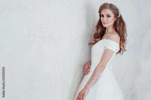 a portrait of the bride before the wedding in white dress