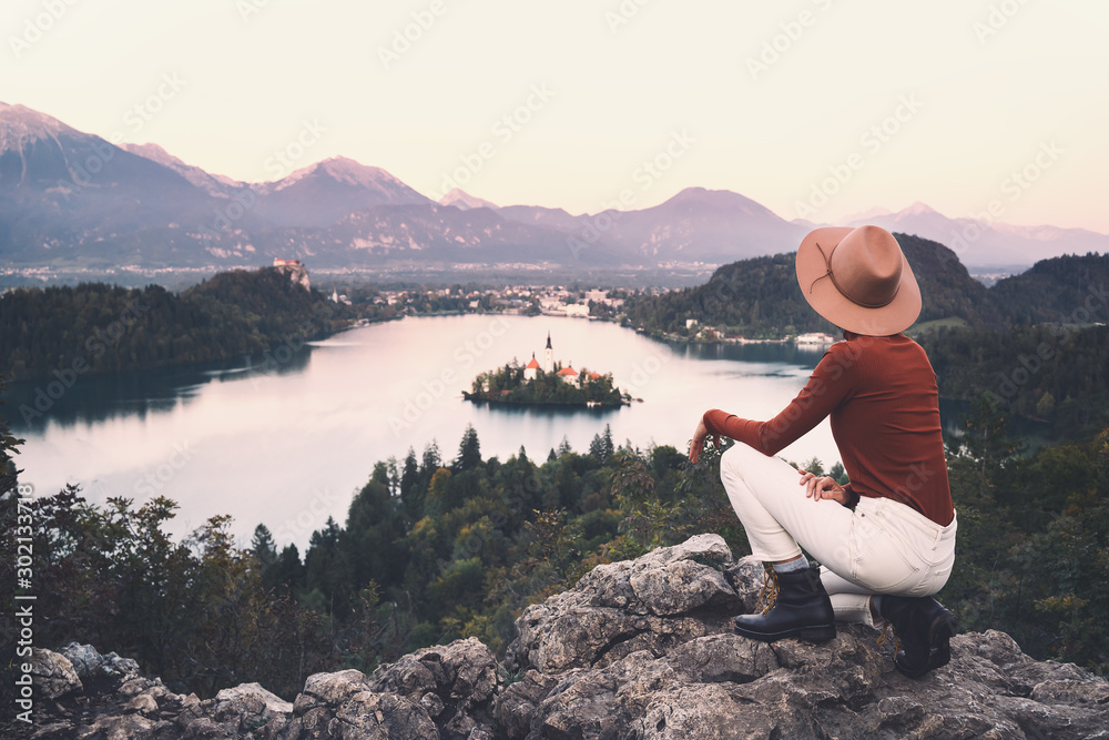 Traveling young woman looking at Bled Lake, Slovenia, Europe