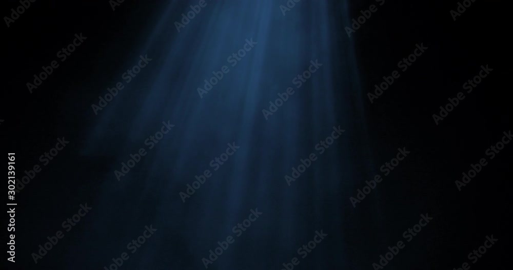 Light rays shining from above coming through deep blue water
