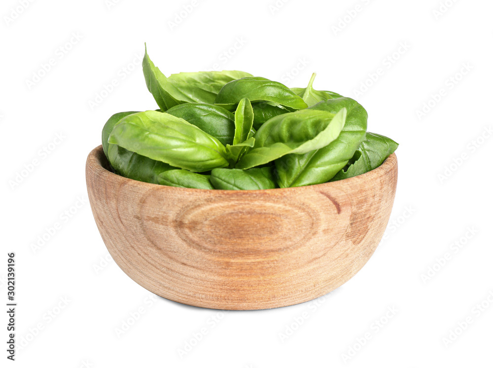 Fresh green basil leaves in wooden bowl isolated on white Fresh green basil leaves in wooden bowl isolated on white