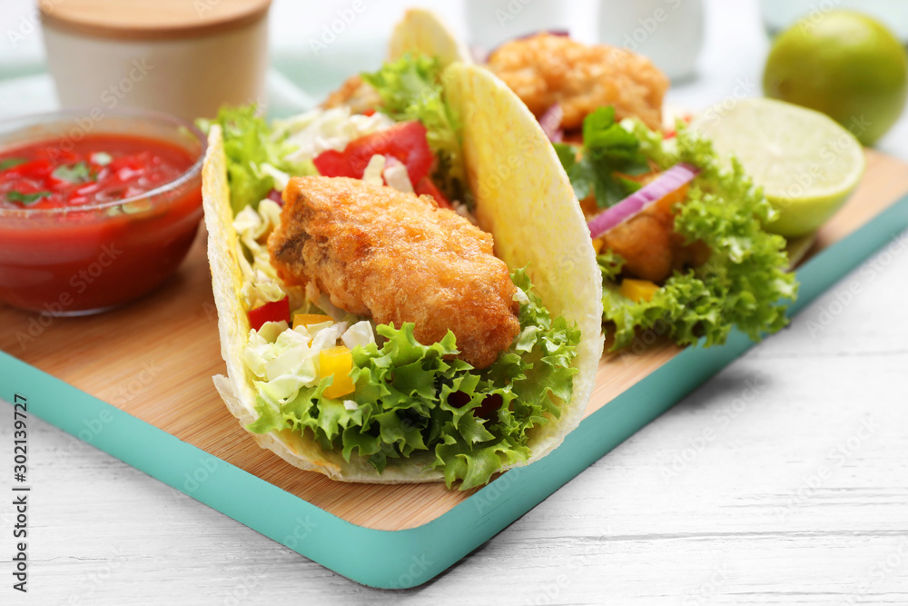 Delicious fish tacos served on white wooden table, closeup Delicious fish tacos served on white wooden table, closeup