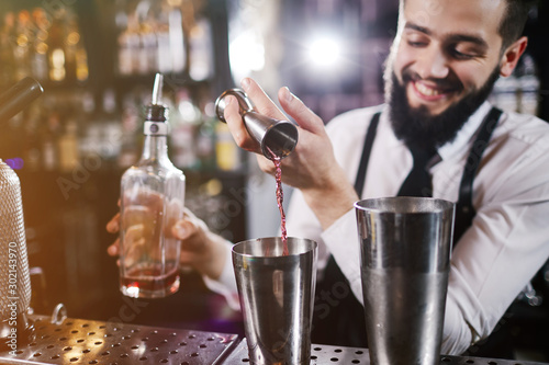 Billede på lærred Professional bartender is making cocktail at night club