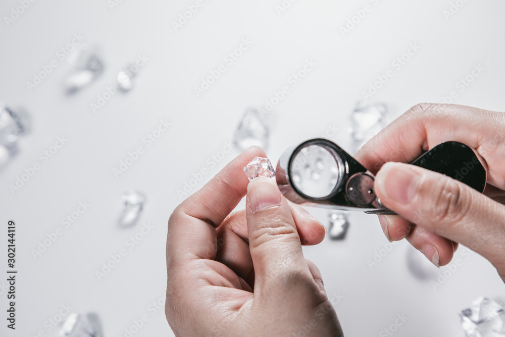 Businessman jeweler during the evaluation of jewels with magnifier. Jeweler looking at diamonds or Luxury stone through loupe evaluating gem a symbol of business success or successful finance concept