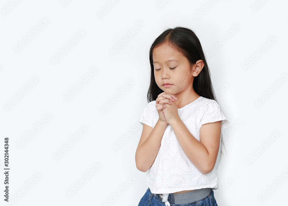 Close eyes beautiful little asian child girl praying isolated on white background with copy space. Spirituality and religion concept. Close eyes beautiful little asian child girl praying isolated on white background with copy space. Spirituality and religion concept.