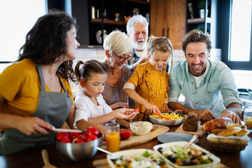 Cheerful family spending good time together while cooking in kitchen
