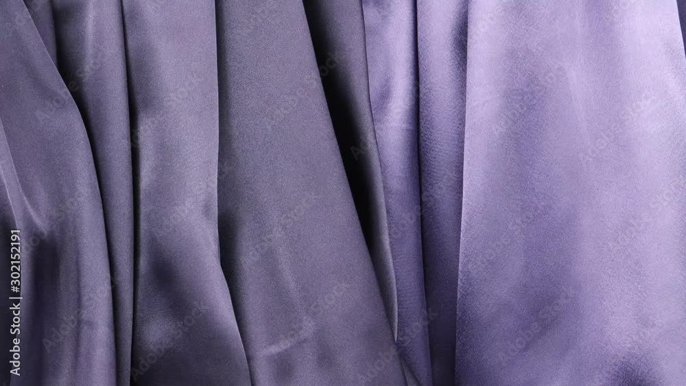Pale lilac and dark lilac satin fabric is draped with vertical soft pleats, background Pale lilac and dark lilac satin fabric is draped with vertical soft pleats, background