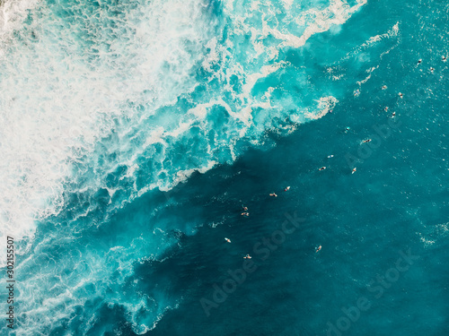 Aerial view with surfers and wave in crystal ocean. Top view