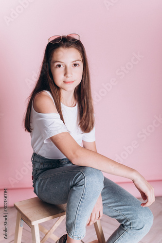 Close up portrait of young cute adorable caucasian kid on soft pink background indoors in studio. Positive concept, childhood happiness concept.