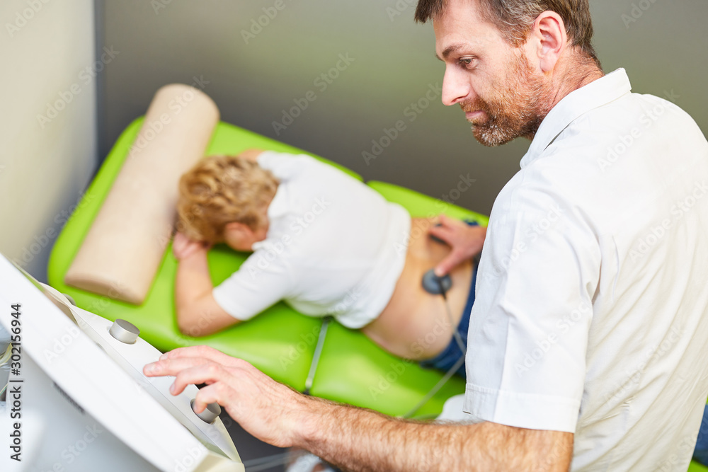 Obraz premium Doctor as orthopedist treats patient with stimulation current