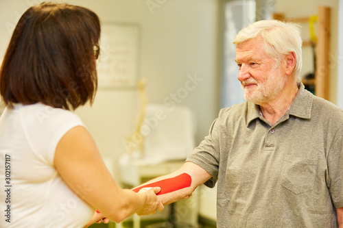 Naturopath attaches Kinesio Tape to her forearm