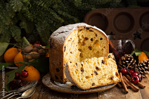 Traditional Christmas panettone with dried fruits and orange zest on rustic background