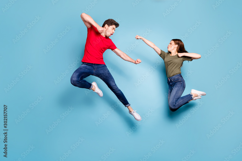 Full size photo of crazy man two people woman man spouses disagree jump  fight kick boxing wear green red t-shirt denim jeans sneakers isolated over  blue color background Stock Photo | Adobe