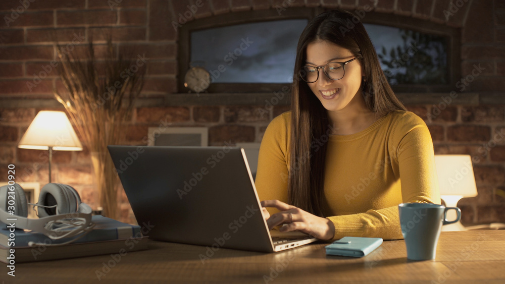 Happy young woman chatting with her laptop