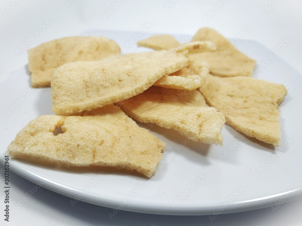 Kerupuk udang or Fried shrimp crackers on a plate and white background Kerupuk udang or Fried shrimp crackers on a plate and white background