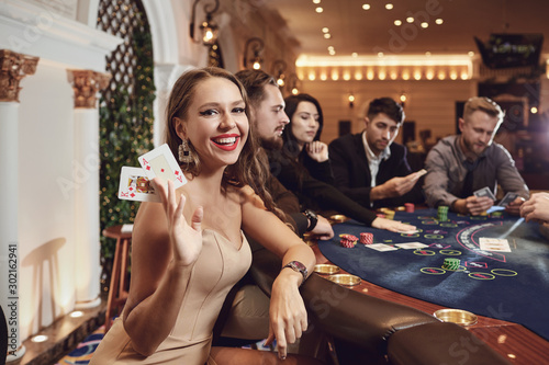 Girl with cards in her hands smiling plays poker in a casino.