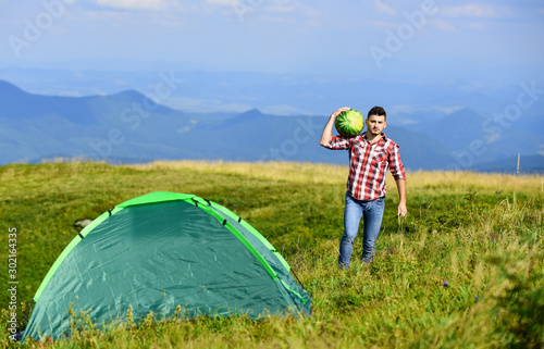 summer camping. man hold watermelon. fruits and vitamins. mountain camping. man live in tent. hiking. mountain traveling. summer vacation. Summer camp.