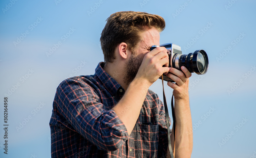 Guy outdoors blue sky background. Handsome blogger guy traveler retro camera. Reporter taking photo. Manual settings. Travel blogger. Vintage equipment. Hipster photographer. Blogger shooting vlog Guy outdoors blue sky background. Handsome blogger guy traveler retro camera. Reporter taking photo. Manual settings. Travel blogger. Vintage equipment. Hipster photographer. Blogger shooting vlog
