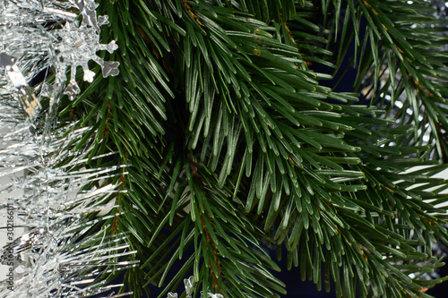 New Year s composition  Christmas decorations. Fir branches next to silver Christmas tinsel. Close-up