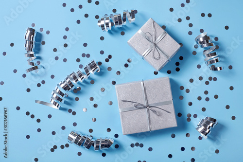 Festive background with gift boxes and decorations on blue background.