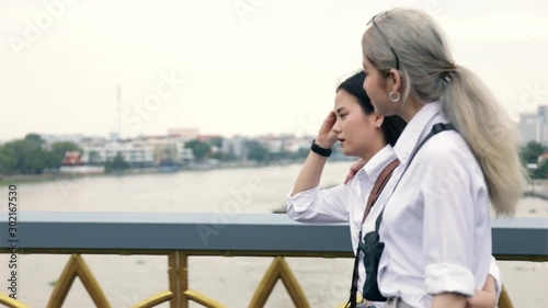 Happy Asian lesbian couple walking on the bridge and having fun in vacation time. LGBT concept. photo