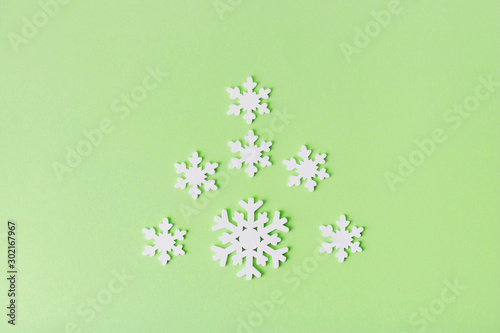 White wooden snowflakes on a mint background.